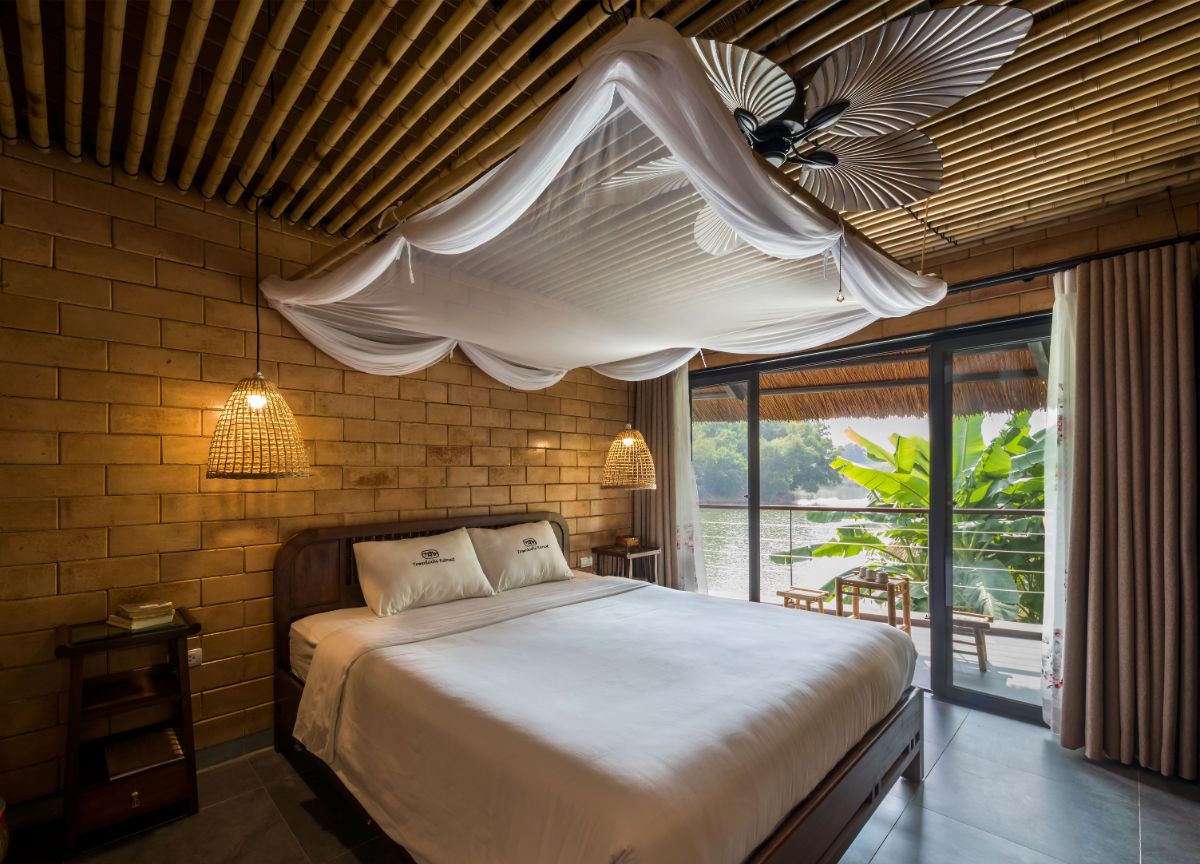 The master bedroom, which features a bamboo ceiling, brick walls, and a glass door leading to the balcony.