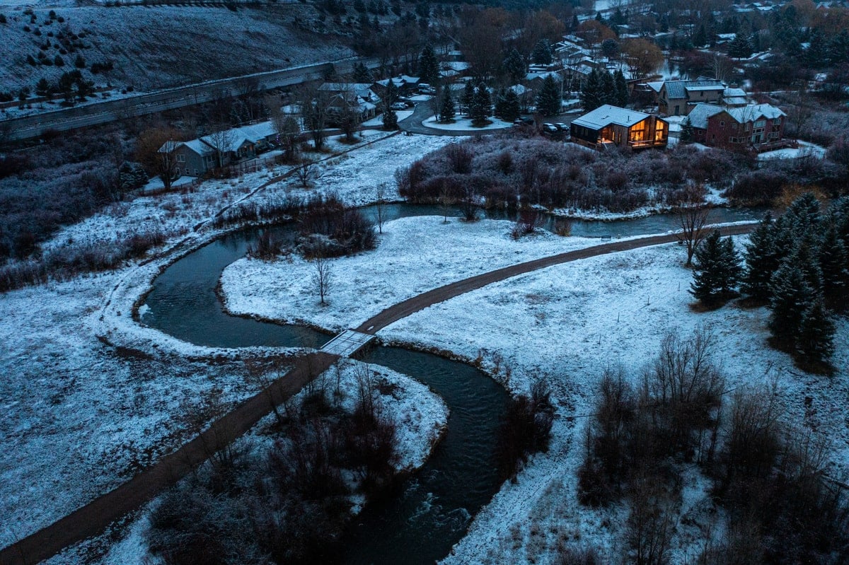 An aerial view of the house during winter along the river.