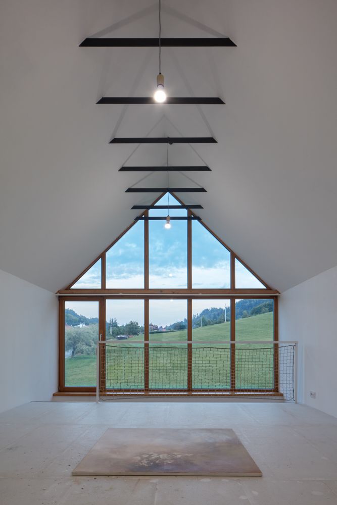 House left wing attic with a view to outside natural greenery in surrounding.