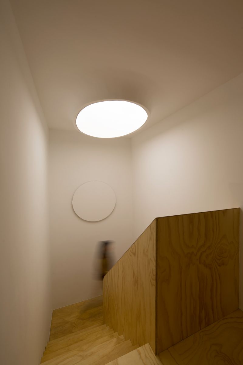 L-shaped wooden stairs with large round lighting.