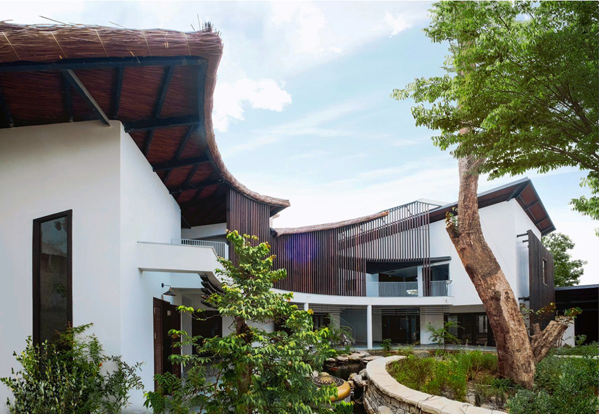 The house facade that features open spaces, large curved corridor, garden, courtyard and atrium.