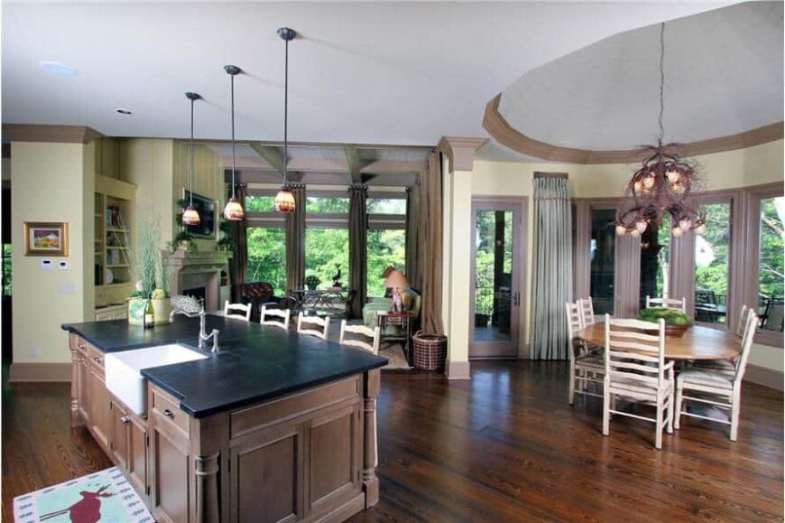 An open layout view of the keeping room, breakfast nook, and kitchen equipped with a breakfast island.