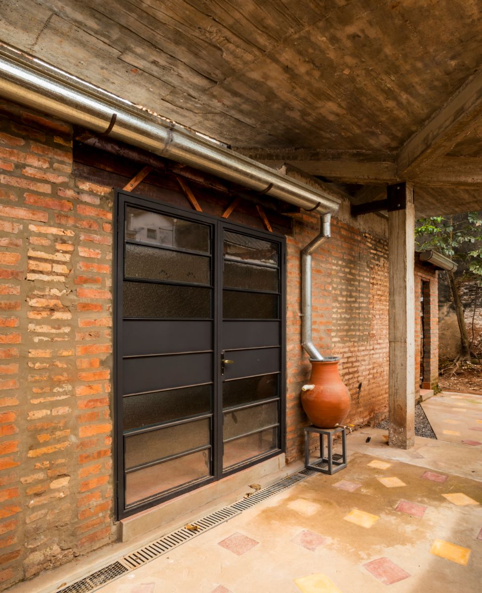 A view of the first floor from the outside, with a brick wall and a glass door.