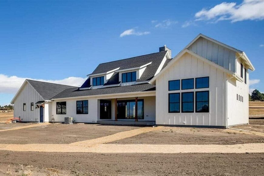 Front exterior view with board and batten siding and a covered porch topped with a couple of shed dormers.