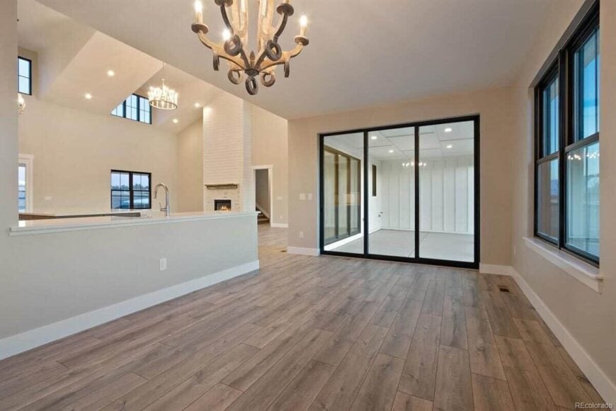 Dining area with a wooden chandelier and sliding glass doors that open to a covered porch.