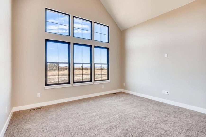 Primary bedroom with a vaulted ceiling and large windows inviting natural light in.