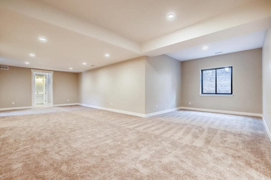 An enormous recreation room brightened by recessed ceiling lights.