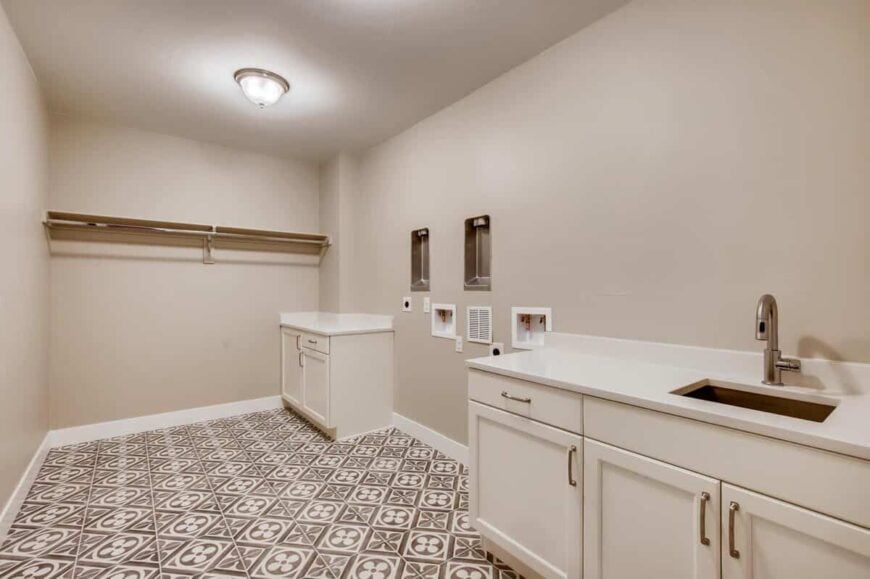Laundry room with multiple counter spaces, an undermount sink, and decorative tile flooring.