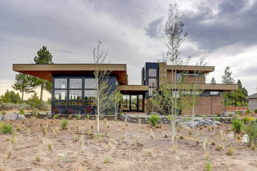 Front exterior view showcasing its concrete panels, wood siding, and stone accents.