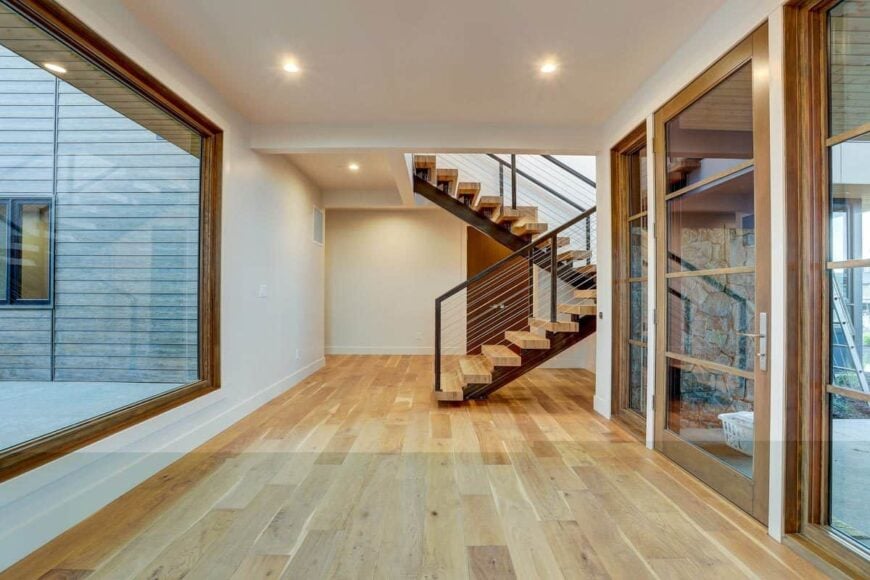The foyer has a glazed entry door, a staircase, and a large picture window.