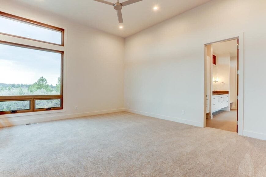 This bedroom has large windows and a private bathroom.