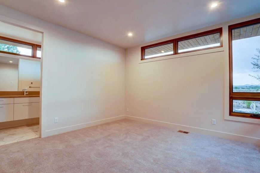 Another bedroom with carpet flooring and a private bathroom.
