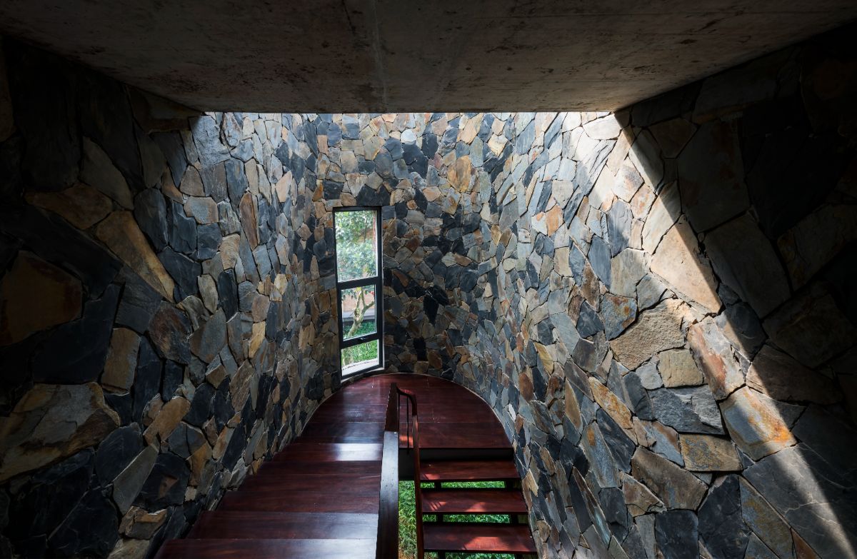 The stairwell has a stone brick wall and a double pane window.