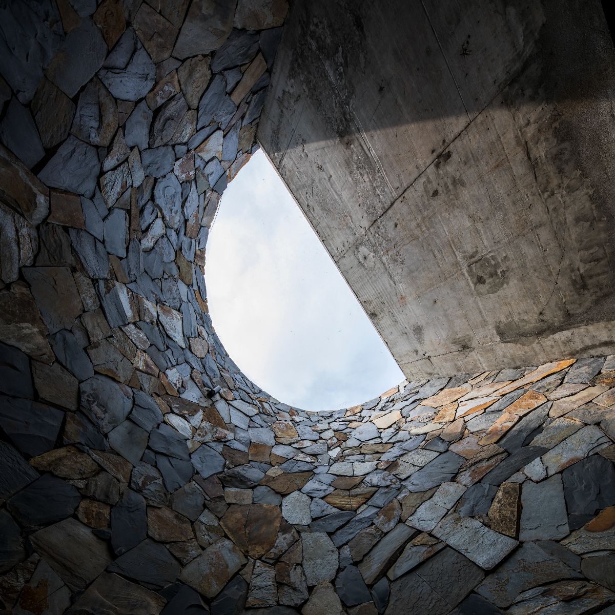 The glass panels that cover the stairwell's roof cast a crescent-shaped shadow.