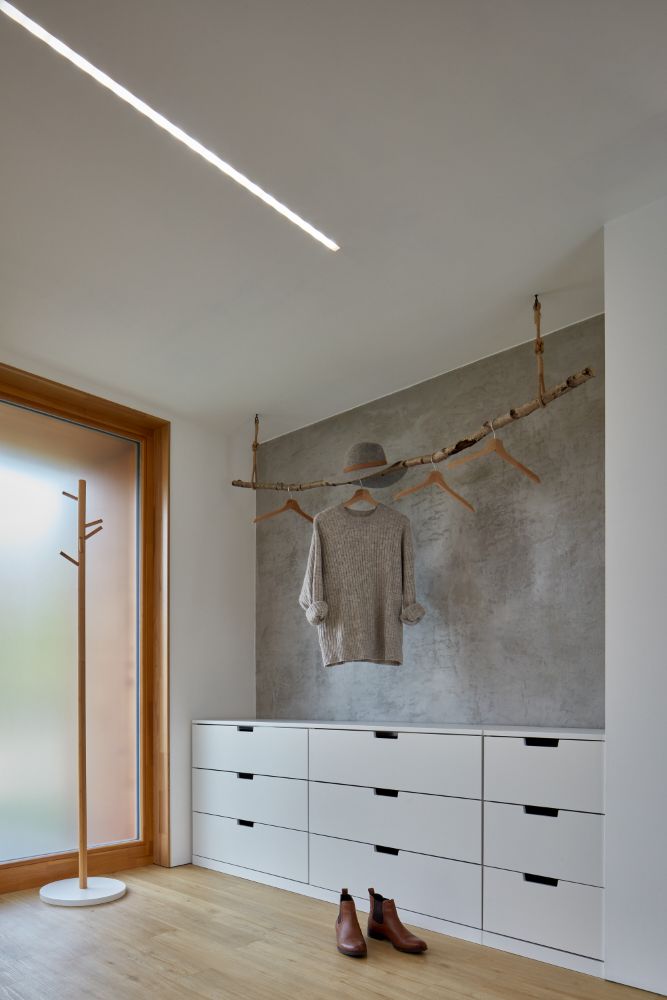 Bedroom area with white painted wooden closet in a shed type of ceiling.