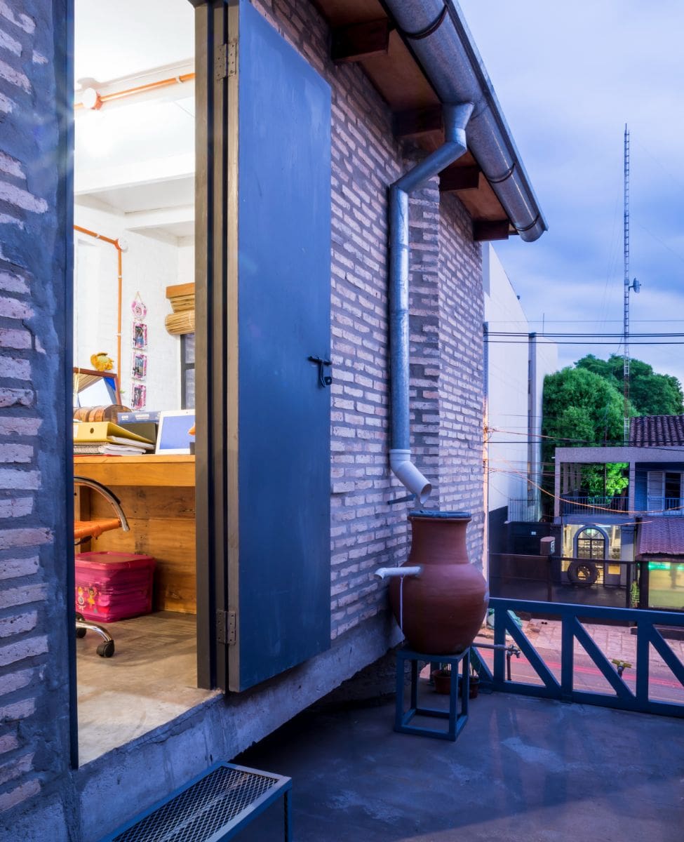 Back view of the upper level with a brick wall and a customized gutter.