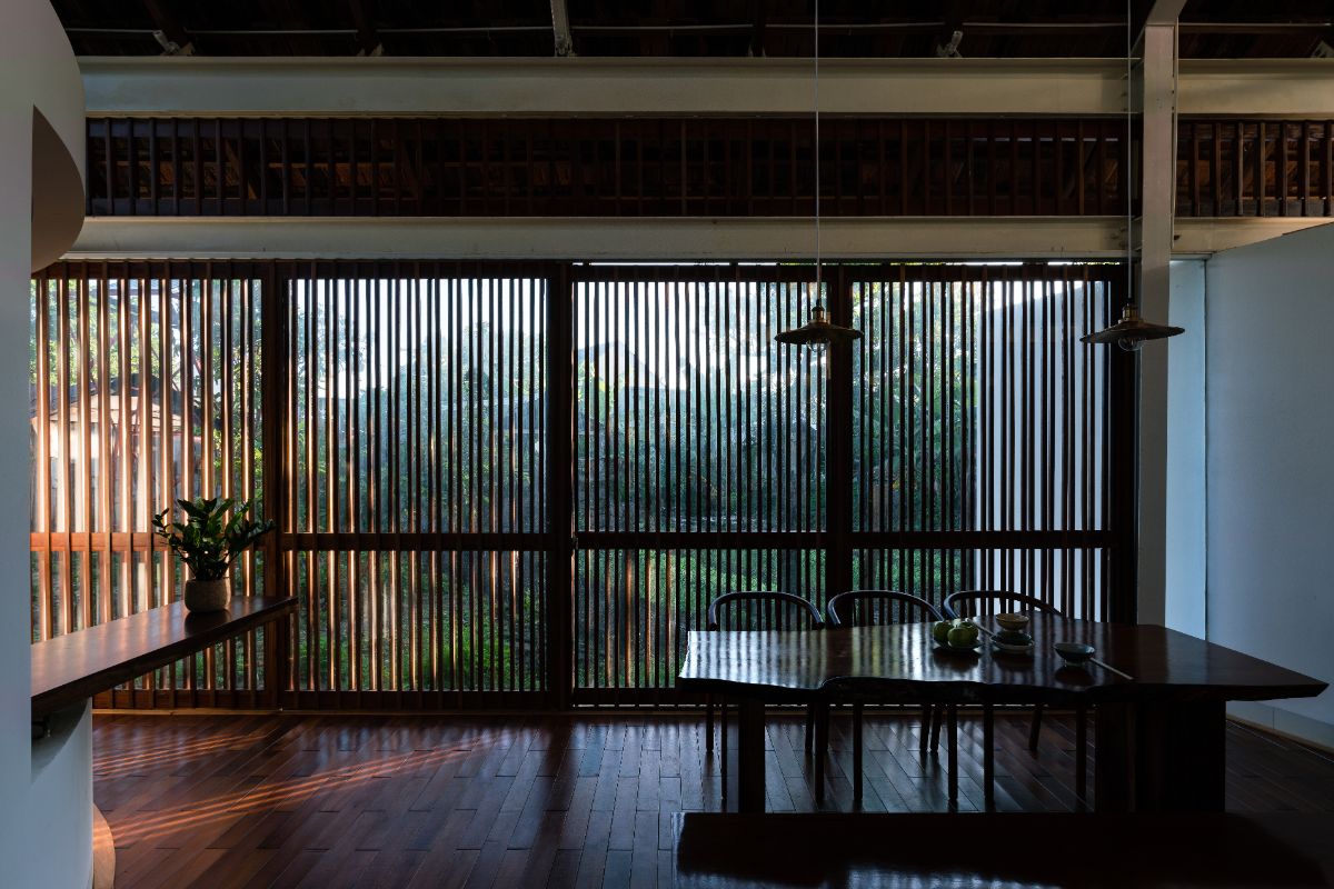 The dining space with the wooden touch design from the table, chairs, flooring, and wall.