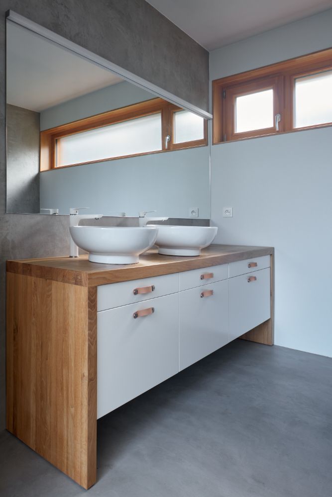 Bathroom area with full length mirror and white table-topped bathroom sink.