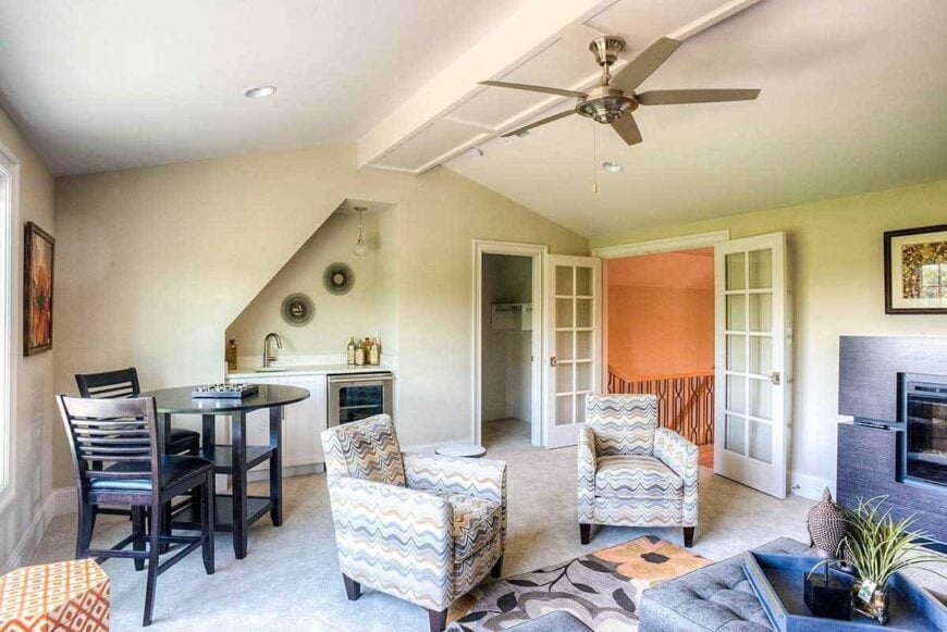 Media room with patterned armchairs, a round dining set, and a small wet bar.