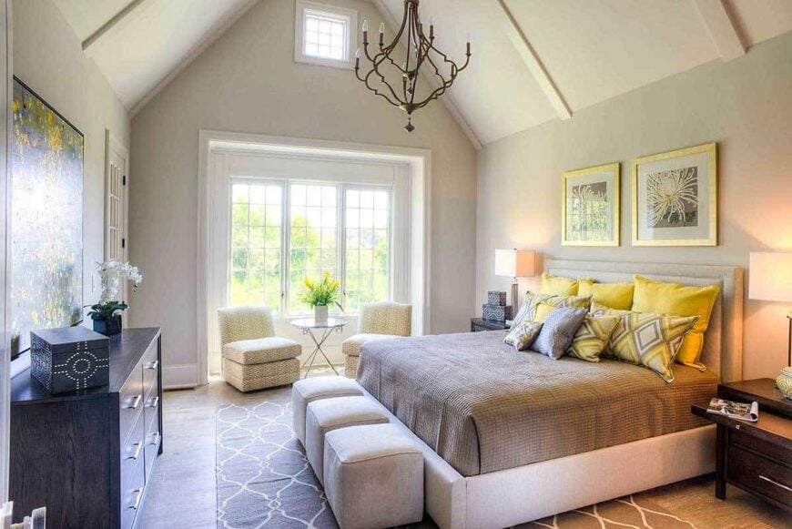 Primary bedroom with a beige platform bed and an ornate chandelier hanging from the cathedral ceiling.