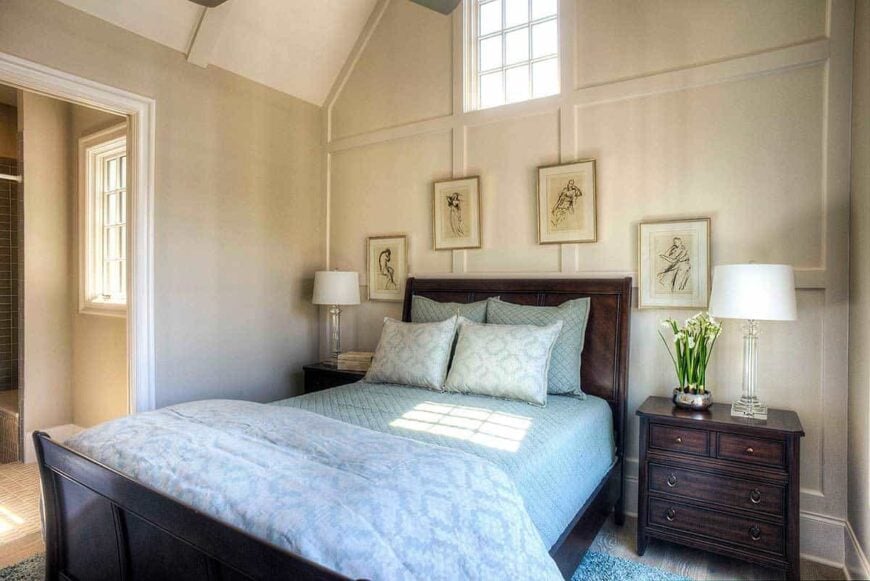 This bedroom has dark wood furnishings and a gray paneled accent wall adorned with framed artworks.