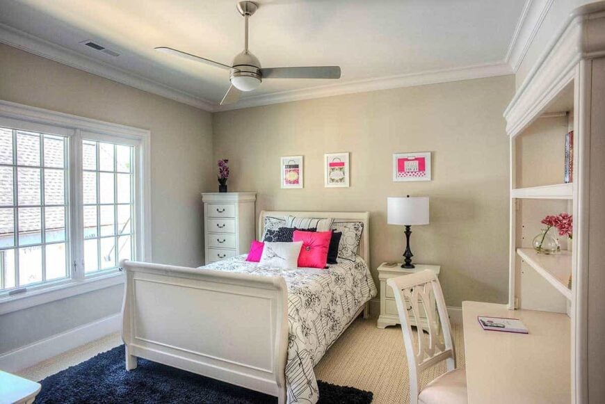 Kid's bedroom with light beige furniture and a dark blue shaggy rug that lays on the carpeted floor.