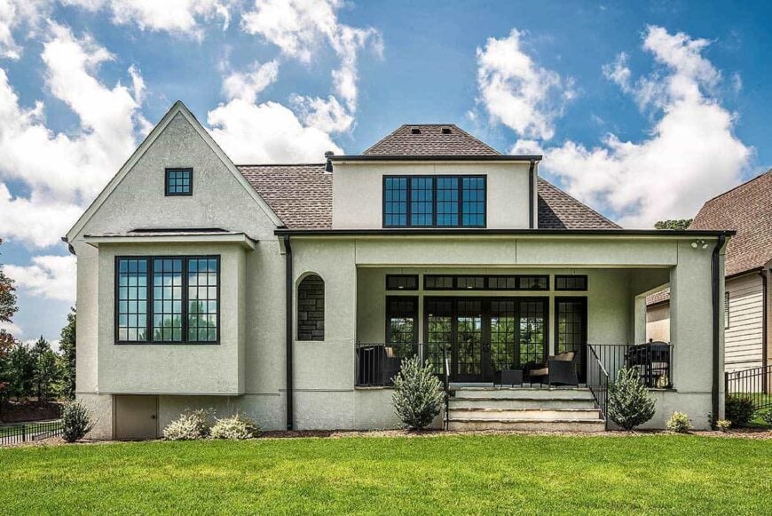 Rear exterior view showcasing its covered porch topped with a large dormer.