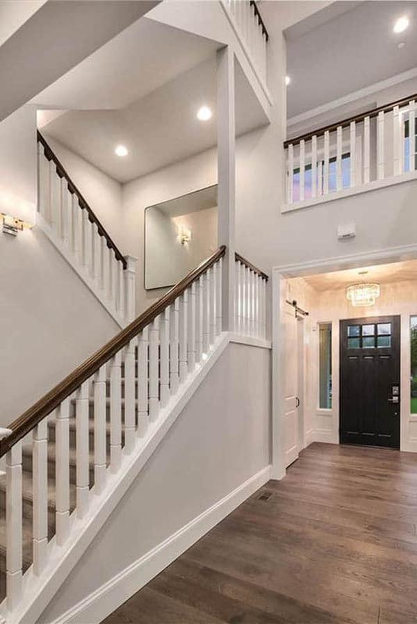 Foyer with a dark wood entry door and a carpeted staircase leading to the upstairs bedrooms.