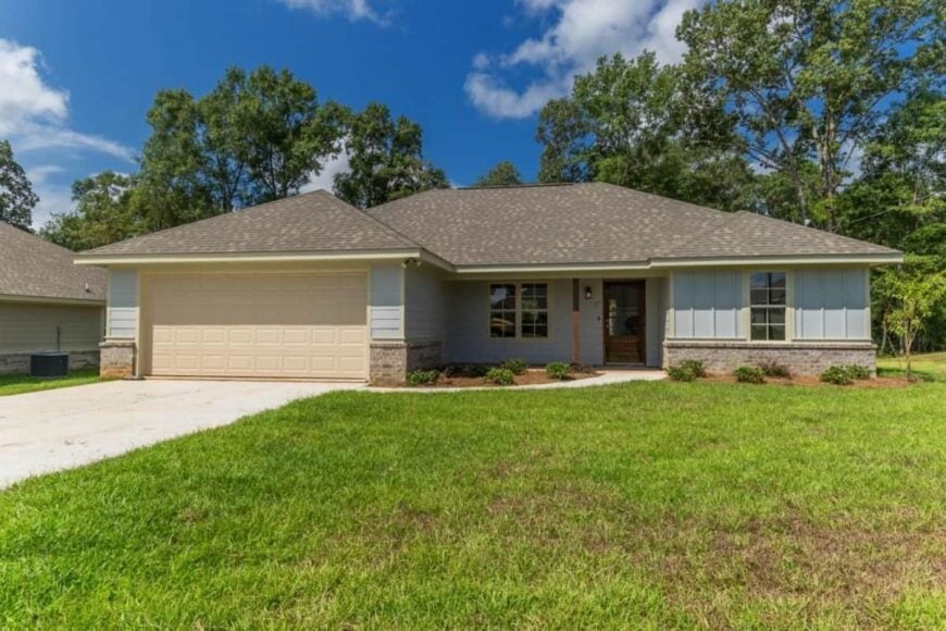 Front exterior view with hipped rooflines, a covered entry porch, and a double front-loading garage complemented with a concrete driveway.