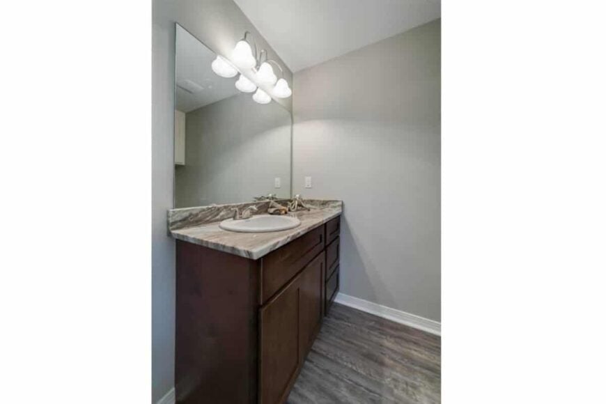 Primary bathroom with a single sink vanity paired with a frameless mirror.