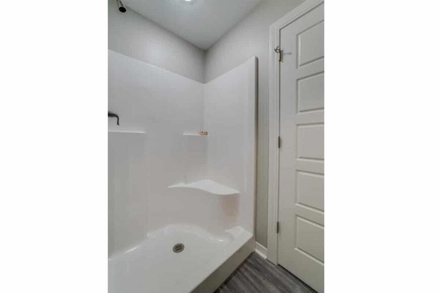 The primary bathroom includes a tub and shower combo with a bench and chrome fixtures.