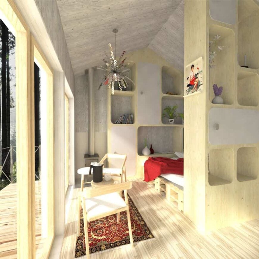 Across the bedroom is a small living area furnished with wooden chairs and tables.