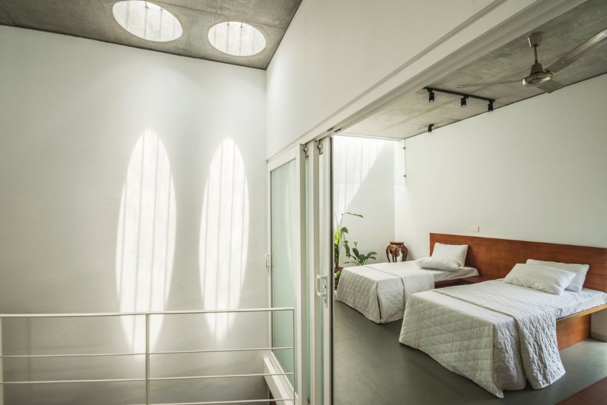 The kids bedroom with two beds and a sliding glass door leading to the terrace.