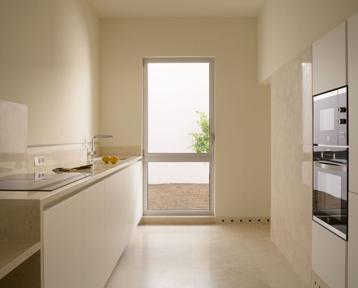 The kitchen area that features a top-of-the-line appliances with full-height door leading to the courtyard.