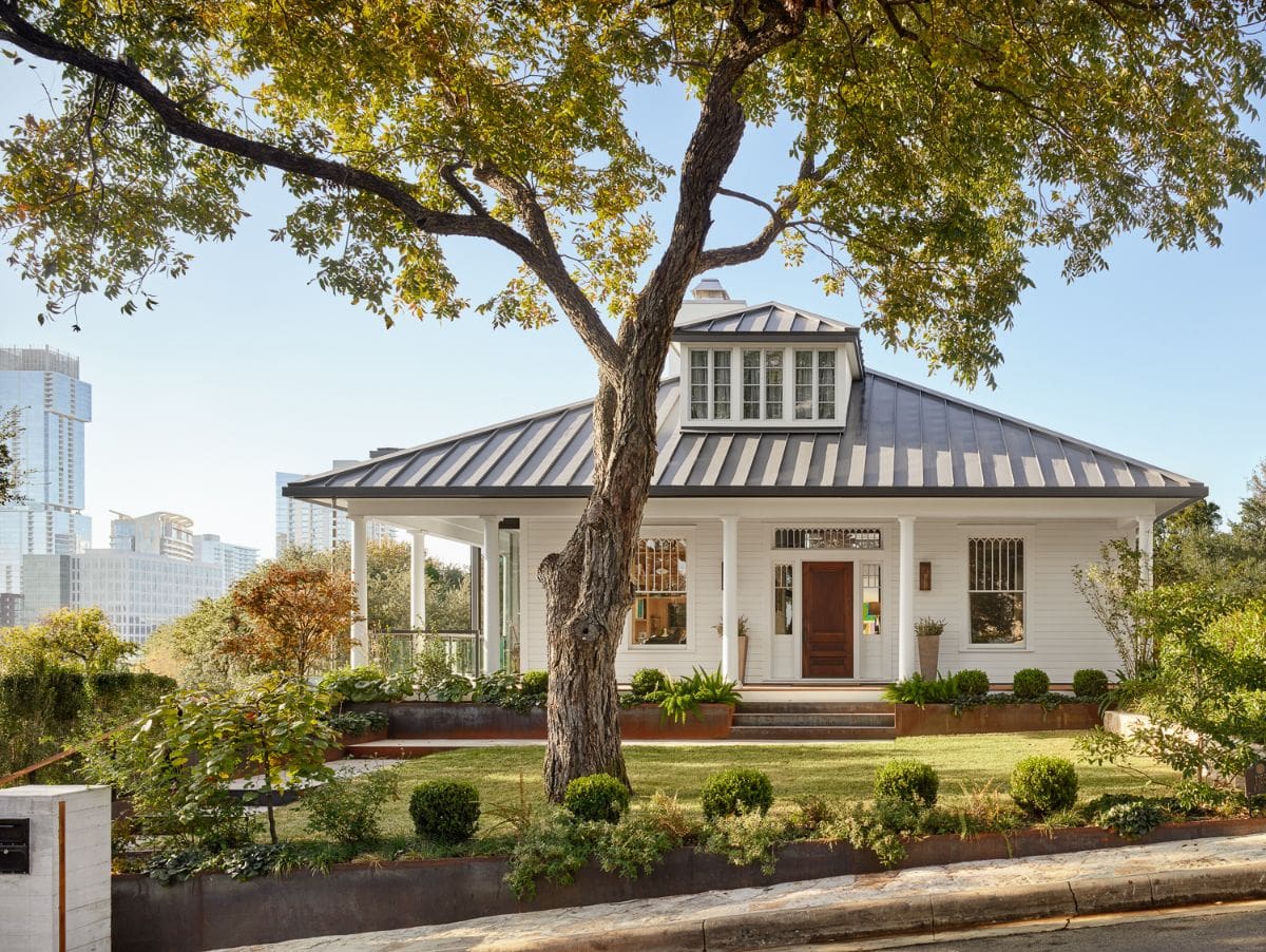 The front facade of the house with manicured landscape in front.