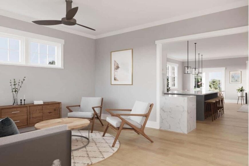 The living room has a beige sofa and cushioned armchairs surrounding a round coffee table.