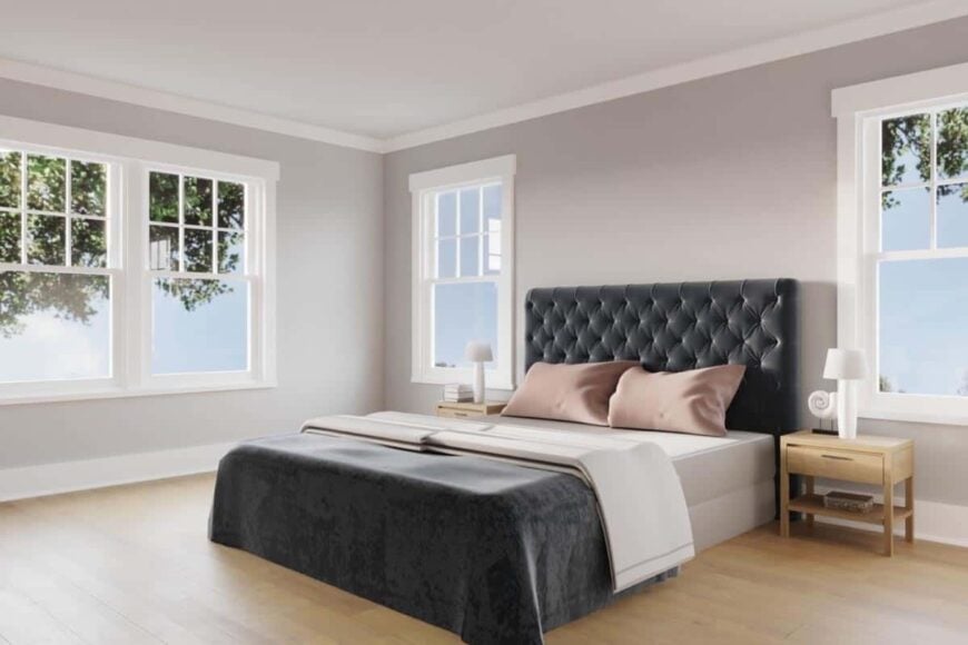 The primary bedroom features a dark tufted bed flanked by wooden nightstands.
