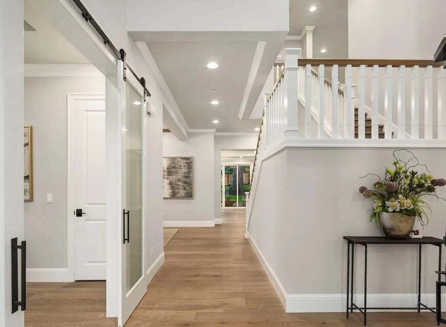 Foyer with a wrought iron console table and sliding barn doors that open to a quiet study.Foyer with a wrought iron console table and sliding barn doors that open to a quiet study.