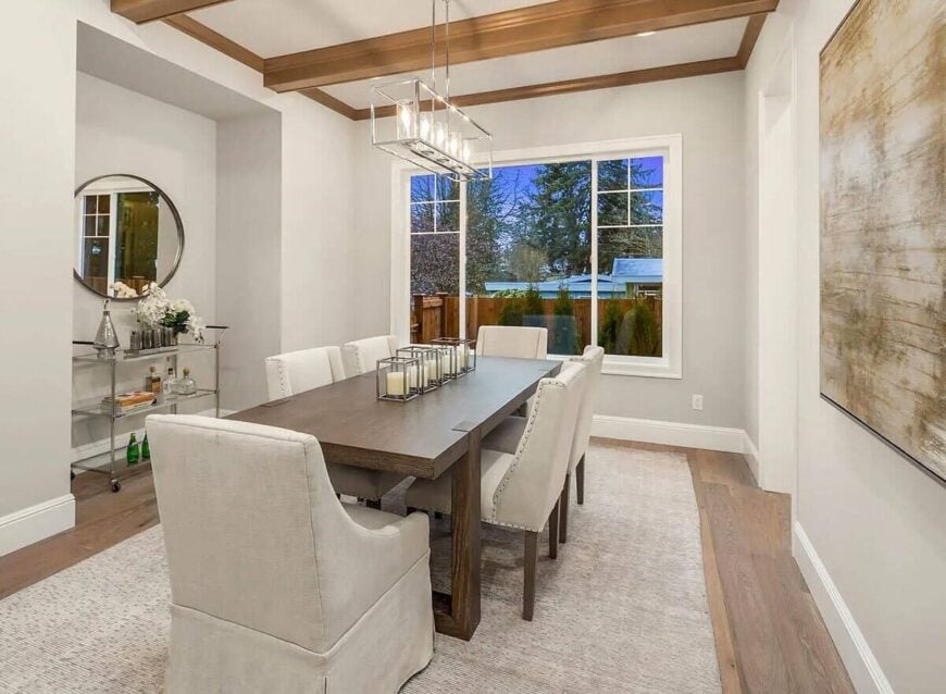 Formal dining room with a rectangular dining set and a buffet trolley topped with a round mirror.