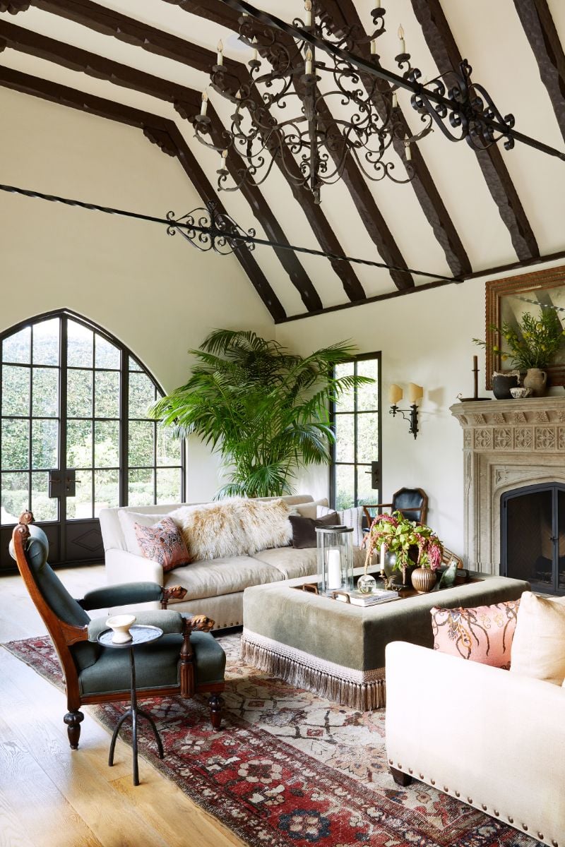The formal living room with big windows looking out onto the garden and a carved-stone fireplace. Image courtesy of Toptenrealestatedeals.com
