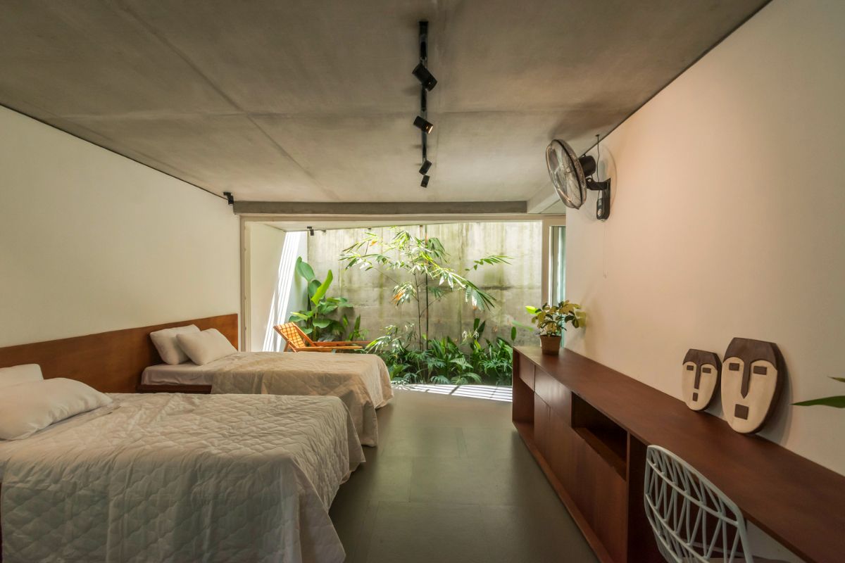 The parents bedroom that consist of two beds. and a glass windows leading to the garden.