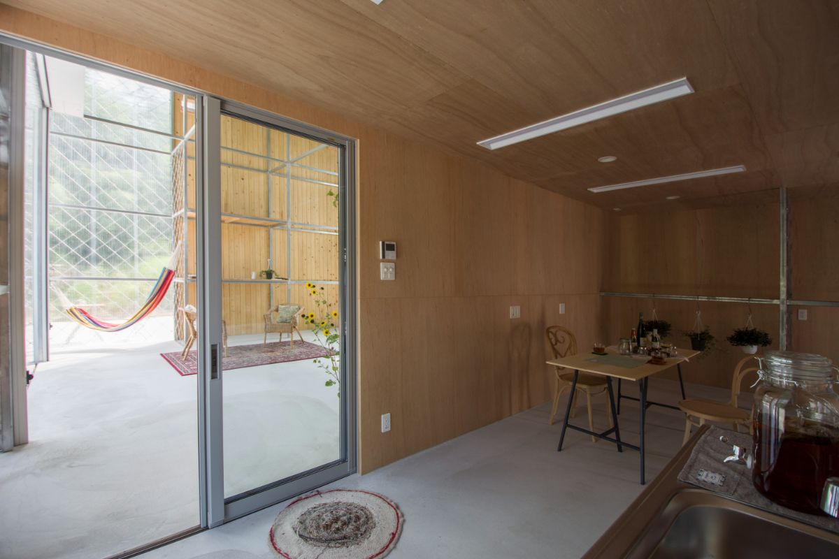 The private room with plywood wall and ceiling and a glass door.