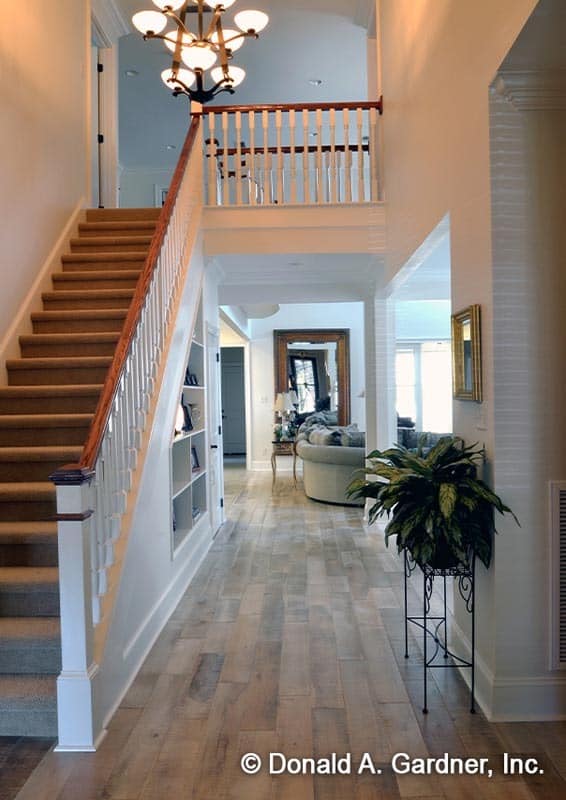 The foyer has a carpeted staircase and a view of the great room.