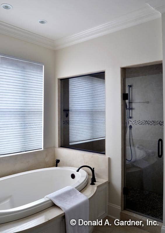 Primary bathroom with a walk-in shower and a drop-in bathtub fitted with wrought iron fixtures.