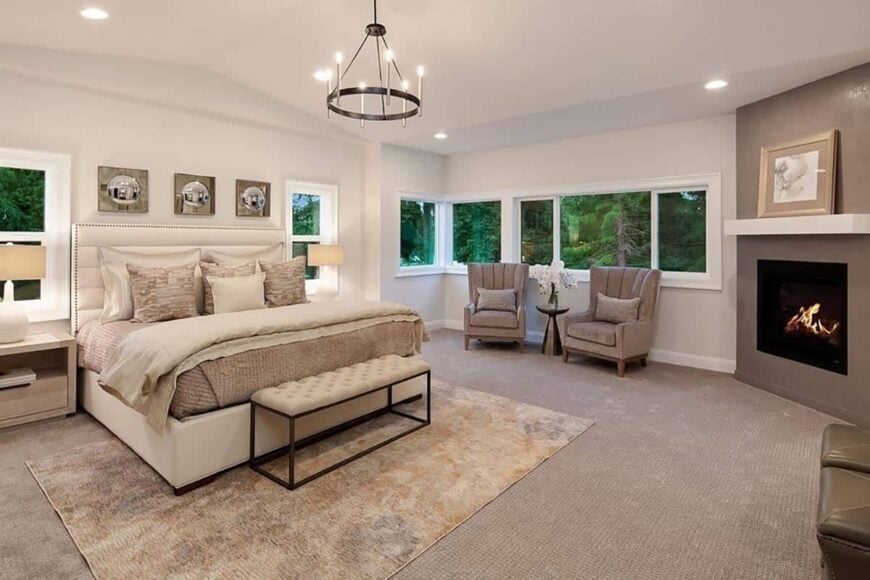 The primary bedroom features a vaulted ceiling, a fireplace, and a sitting area by the sliding windows.