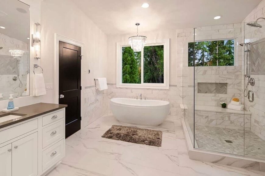 The primary bathroom includes a freestanding tub and a walk-in shower with a tiled bench and chrome fixtures.