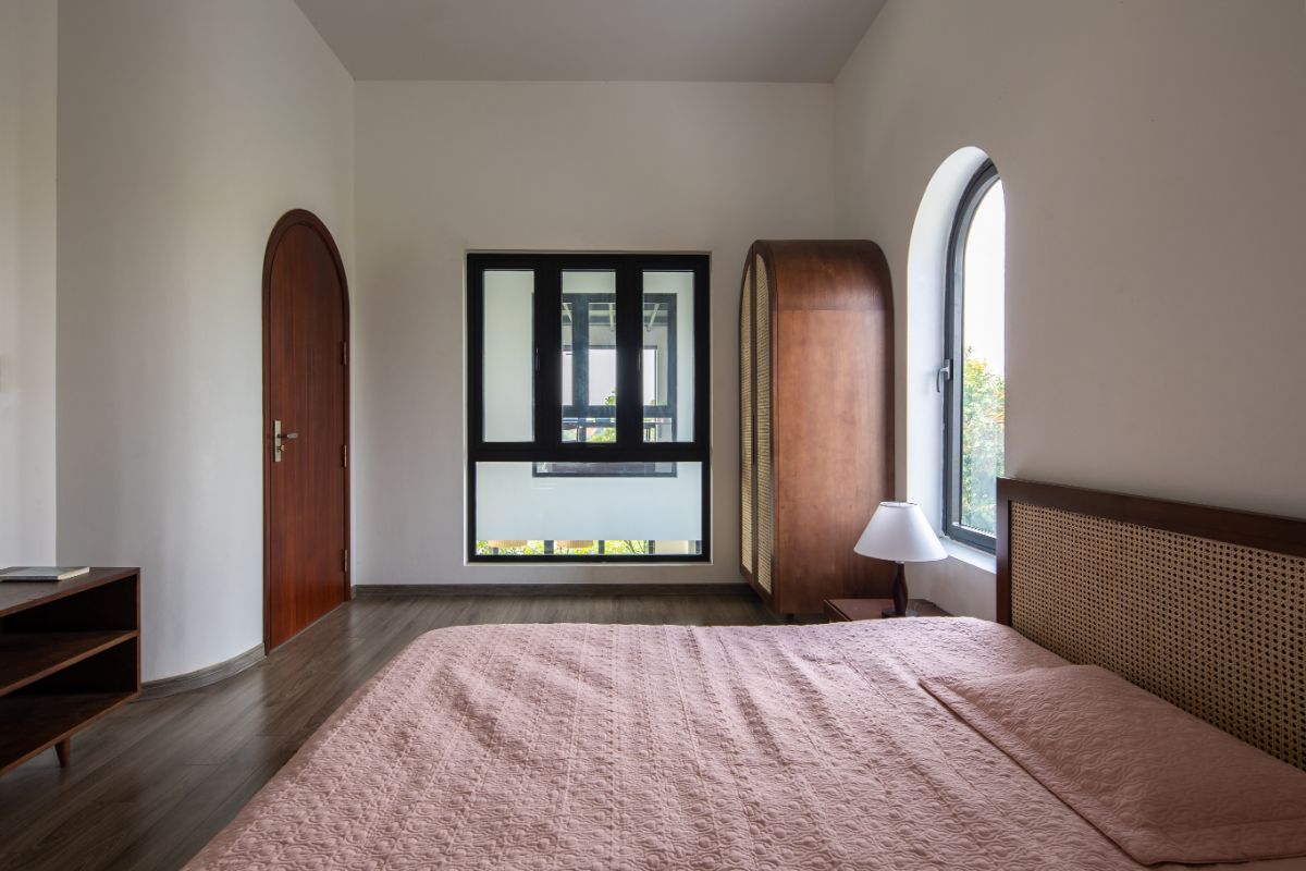 The bedroom that highlight an arc door, cabinets, and windows.