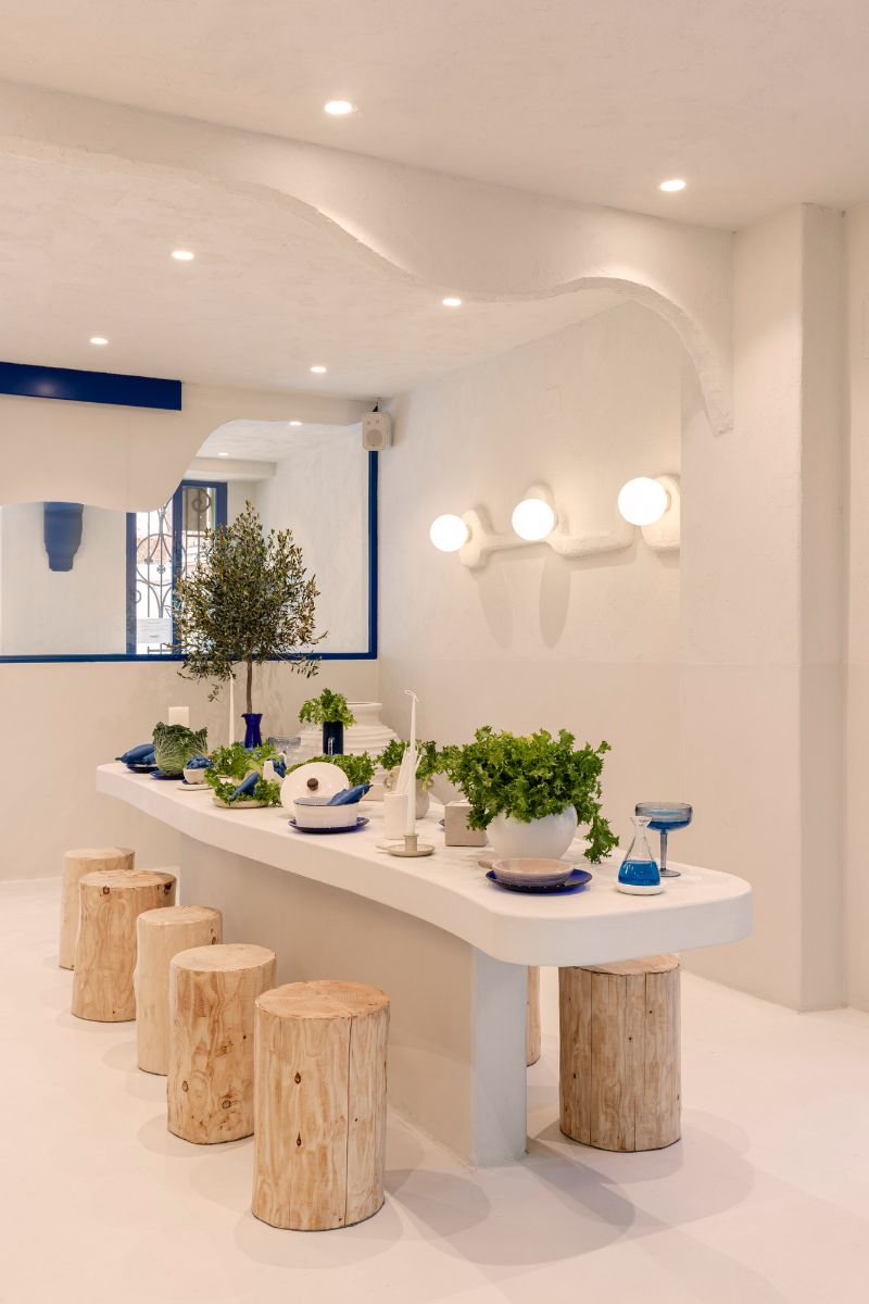A long cementish table that highlight a stucco-like finish wall.
