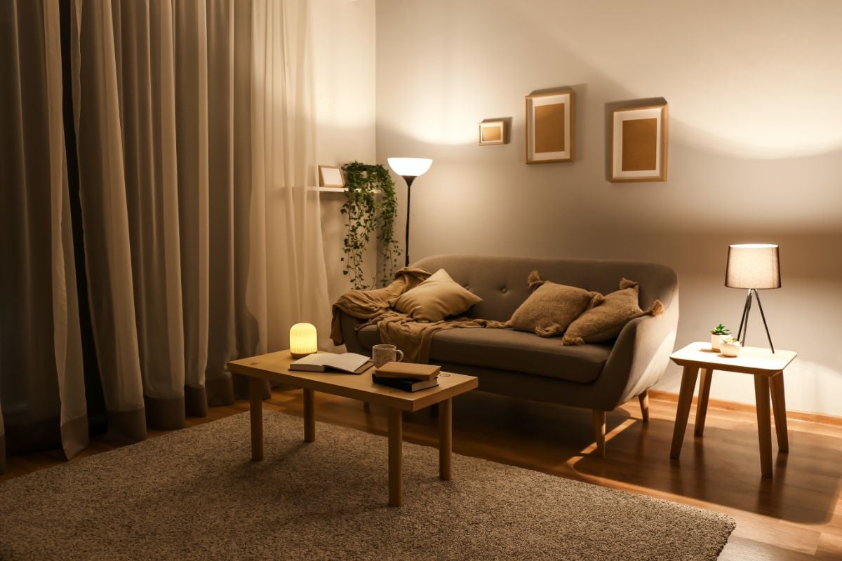 A living room with daybed and lampshade.