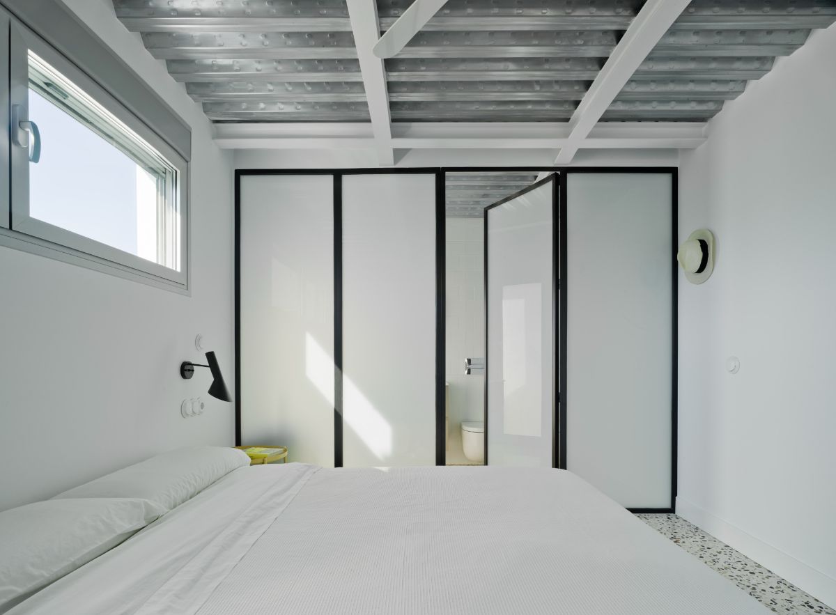 The primary bedroom with glass doors leading to the bathrom.